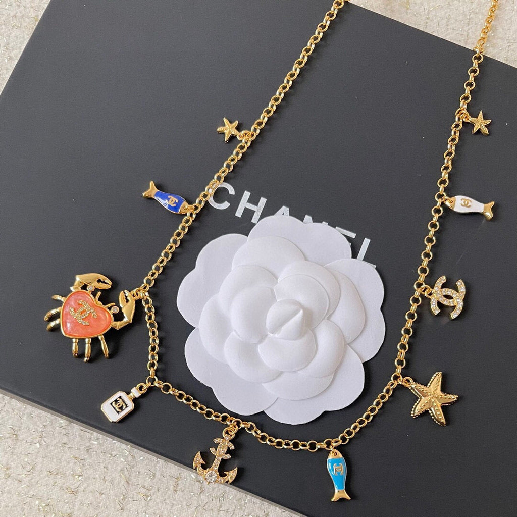 MULTI-CHARM CHAIN BELT IN GOLD METAL CRYSTAL DOUBLE C PENDANT AND OCEAN MOTIFS